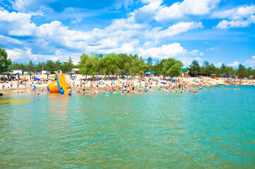A beach with a very large number of tourists, a view from the water. View of the beach from the...