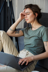 Attractive young woman sitting at the couch on a floor of a living room