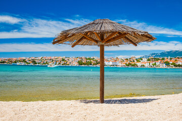 Adriatic sea shore in Croatia on Pag island, parasol on beautiful sand beach in town of Novalja
