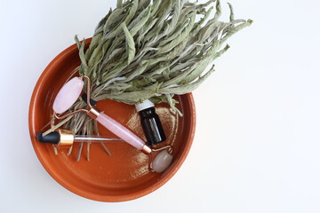 Pink face roller laying on white background. Beauty tools. Quartz derma roller for skin treatment. 	