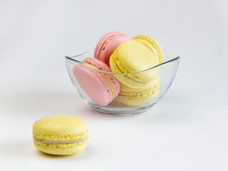 Closeup of rench macarons pink and yellow colors in glassware on light background.