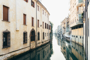 Fototapeta na wymiar View of old houses and their reflection in a water canal Padua.