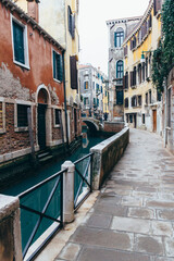 Fototapeta na wymiar Narrow canal and unique street in Venice Italy. venice postcard. Vertical shot.