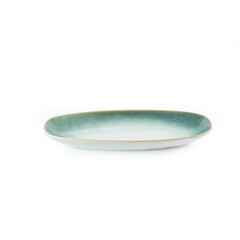 Closeup shot of a white and green oval ceramic plate isolated on a white background