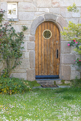 Old curvy wooden door on stone wall