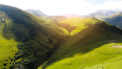 Panorama of beautiful springtime landscape in the mountains. Grassy field and rolling hills.