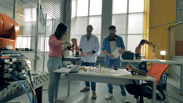 Team of software experts are observing bionic parts and talking