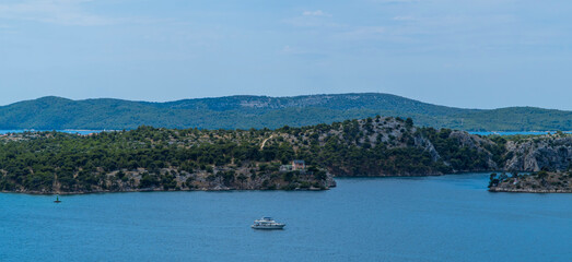 Aerial panoramic view of boat going through the canal in front of islands in Sibenik, Dalmatia, Croatia