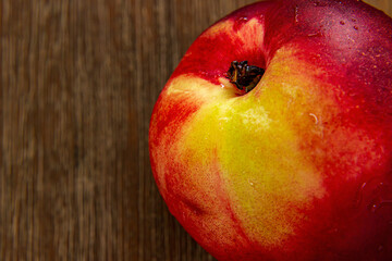 Fresh slightly damp nectarine on a brown table