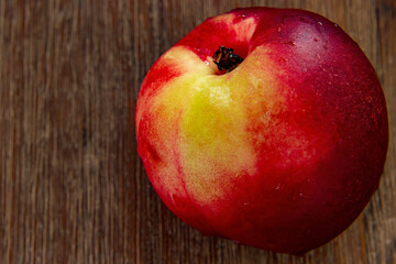 Fresh slightly damp nectarine on a brown table