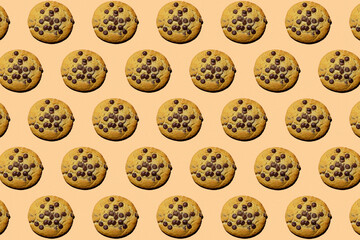 Pattern of oatmeal cookies with chocolate crisps on a beige background. Flatley with hard shadows. homemade baking