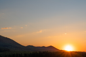 A beautiful scenery of a mountain range with the sunset in the background