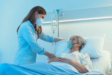 Nurse wearing a surgical mask checking on patient