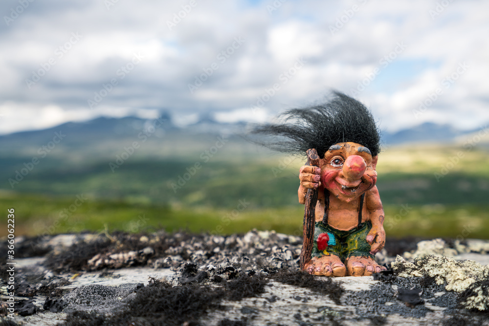 Wall mural funny norwegian troll figure with big nose and walking stick outdoors in the mountains. hair standin - Wall murals