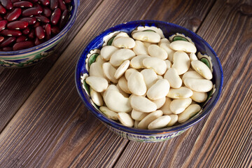White beans in a bowl on wooden background. Vegan food. Close up.