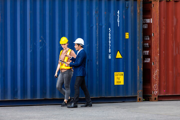 Man manager and woman Supervisor dock cargo checking and control loading Containers box at container yard port of import and export goods. Unity and teamwork concept