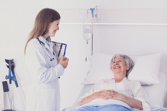 Doctor or nurse chatting to a senior woman patient