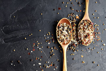 Variety of colorful spices in wooden spoons. Sea salt, mixed pepper, cardamon and mustard seeds on...