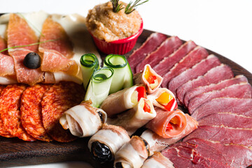 Assortment of cold meats, variety of processed cold meat products on a wooden board