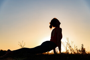 girl doing yoga in nature at sunset