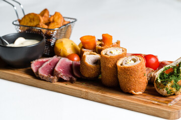Mixed meats andvegetalbes served on wooden board