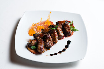 Bacon beef rolls with decoration on white plate