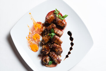 Bacon beef rolls with decoration on white plate
