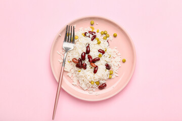 Plate with tasty rice and beans on color background
