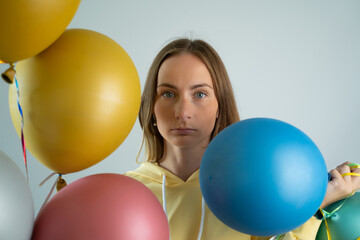 Portrait of a sad woman at a party. upset girl on a holiday with balloons.