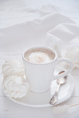 Coffee and marshmallow on a white wooden background