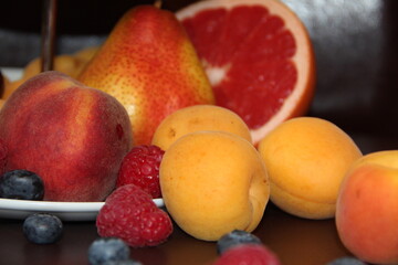 Fruit and berry plate. Bright different fruits on a dark surface.