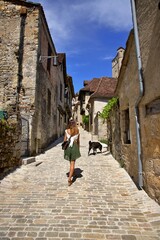 Fototapeta na wymiar Tourisme France - jeune femme village ancien rue marche été - voyage découverte exploration