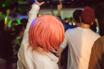 クラブで盛り上がって手を挙げている女性