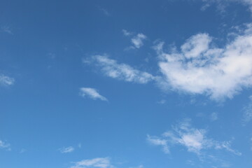 White feather clouds in a blue sky. Backgrounds