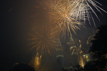 Kuala Lumpur, Malaysia – January 1, 2020: Colourful Fireworks spark during New Year at the Kuala Lumpur City. The image contains certain grain or noise and soft focus.