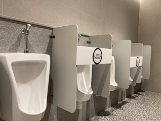 Social distance between urinals male in toilets public to avoid infection risk.