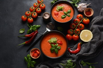 Fototapeta na wymiar Andalusian gazpacho. Red tomato cold gazpacho soup in glass, with cucumber, onion, basil ,chili peppers and croutons.