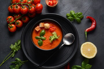 Andalusian gazpacho. Red tomato cold gazpacho soup in glass, with cucumber, onion, basil ,chili peppers and croutons.