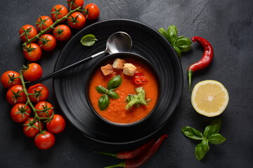 Andalusian gazpacho. Red tomato cold gazpacho soup in glass, with cucumber, onion, basil ,chili peppers and croutons.