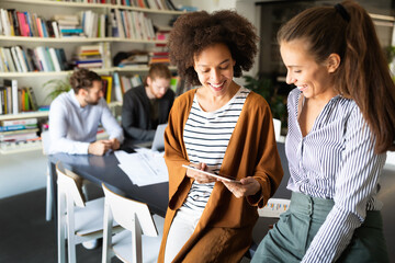 Happy young business people colleagues talking working in office