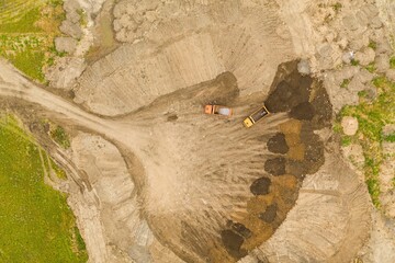 Mining truck in a clay open cast mine. Heavy industry from above. Industrial background from devastated landscape. Aerial view.
