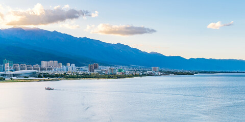 Yachts in Erhai Sea at dusk and in Dali City, Yunnan Province, China © Govan