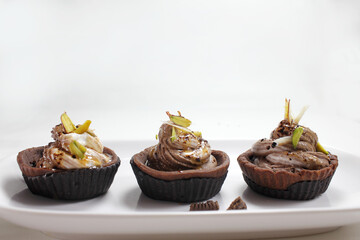 Homemade choco tart or mufins served with whipped cream,chocolate and dryfruits.