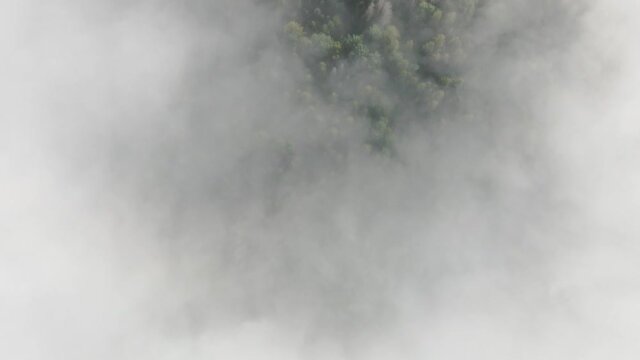 Flying through the clouds above mountain tops. High peaks wonderful morning sunrise natural Landscape