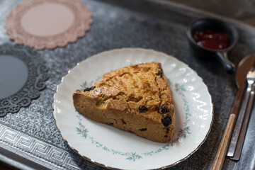 Scones with chocolate chips lined up on a white plate.