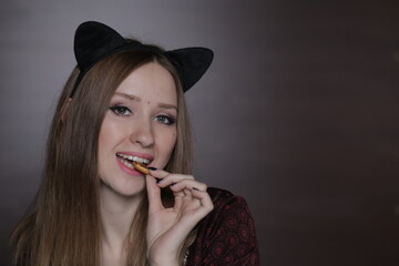 Obraz premium Beautiful young woman with black cat ears on the head