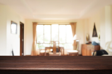 Empty wooden desk space and blurry background of home window for product display montage.