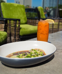 Bright orange fruit beverage with edamame appetizer .
