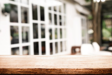 Empty wooden desk space and blurry background of cafe or Restaurant for product display montage.