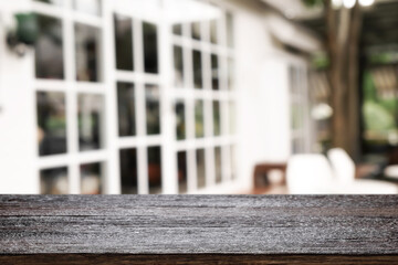 Empty wooden desk space and blurry background of cafe or Restaurant for product display montage.
